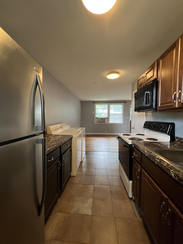 kitchen with light tile patterned floors, washer / clothes dryer, freestanding refrigerator, black microwave, and range with electric stovetop