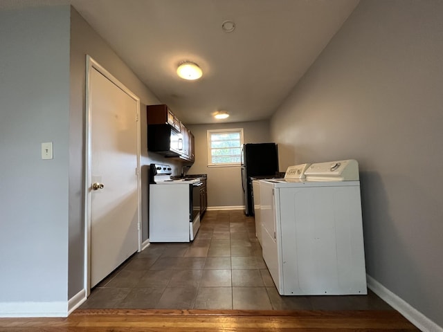 laundry area featuring laundry area, tile patterned floors, baseboards, and washing machine and clothes dryer