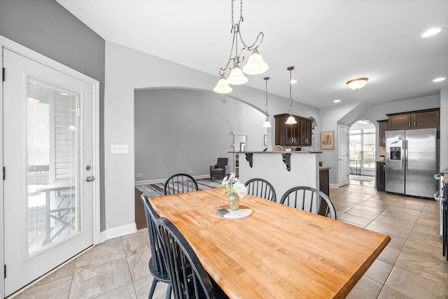 dining area featuring arched walkways, recessed lighting, baseboards, and light tile patterned floors