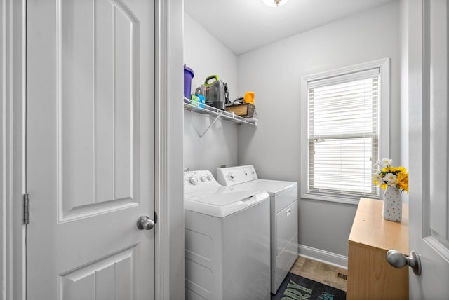 washroom with laundry area, independent washer and dryer, and baseboards