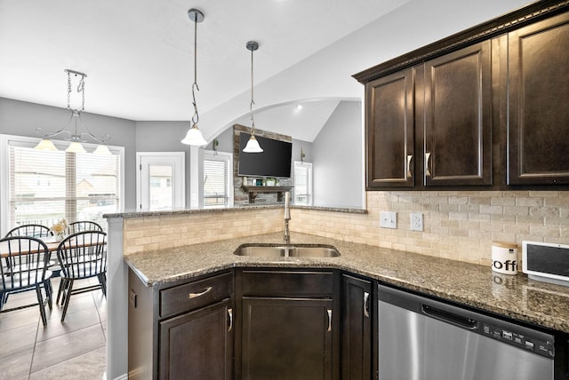 kitchen featuring dark stone countertops, plenty of natural light, dishwasher, and a sink