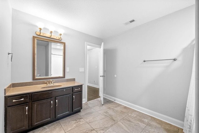 bathroom featuring visible vents, vanity, and baseboards