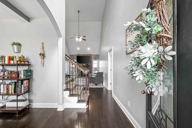 foyer entrance with a ceiling fan, stairway, baseboards, and wood finished floors