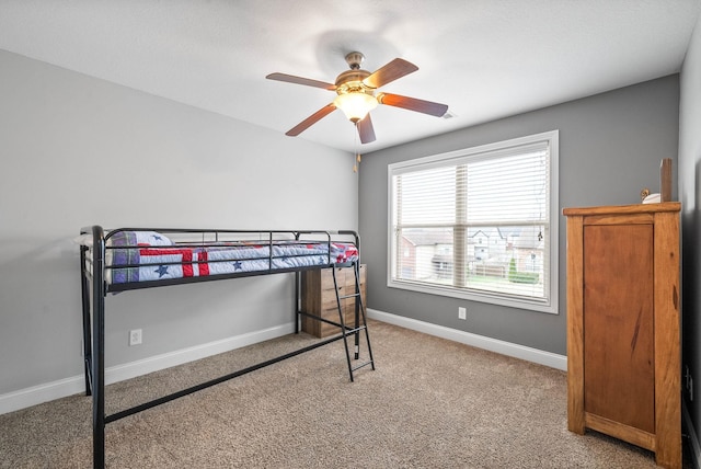 carpeted bedroom featuring ceiling fan and baseboards