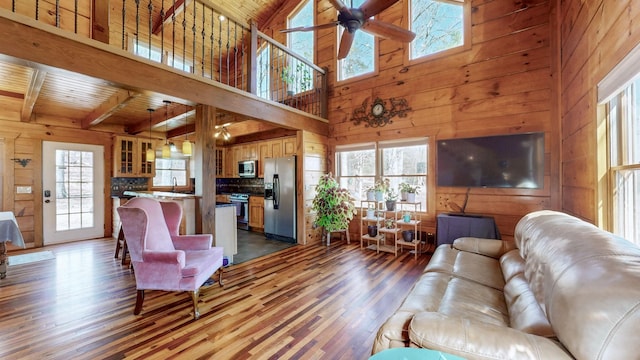 living room with a healthy amount of sunlight, wood walls, and wood finished floors