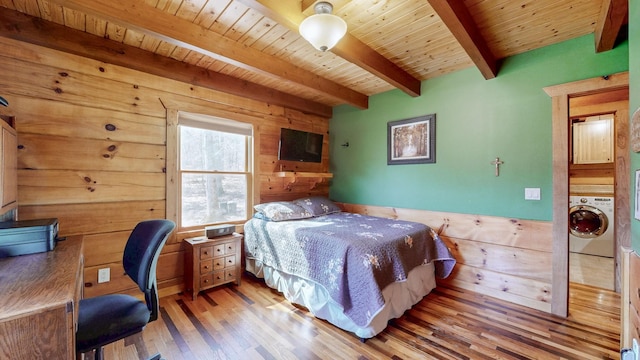 bedroom with wooden ceiling, washer / dryer, beam ceiling, and wood walls