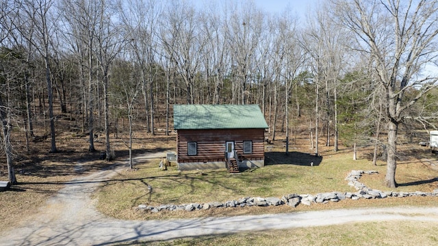 exterior space featuring metal roof, driveway, and a yard