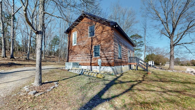 view of home's exterior featuring cooling unit, a lawn, and dirt driveway