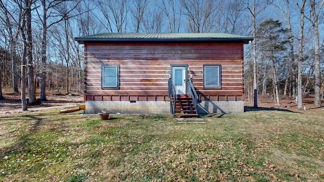 view of front of home with entry steps, crawl space, metal roof, and a front yard