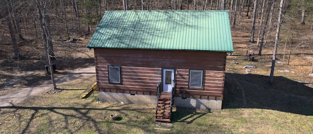 view of property exterior featuring entry steps, metal roof, and crawl space