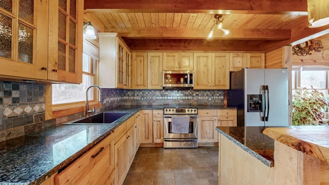 kitchen with light brown cabinetry, appliances with stainless steel finishes, backsplash, and a sink