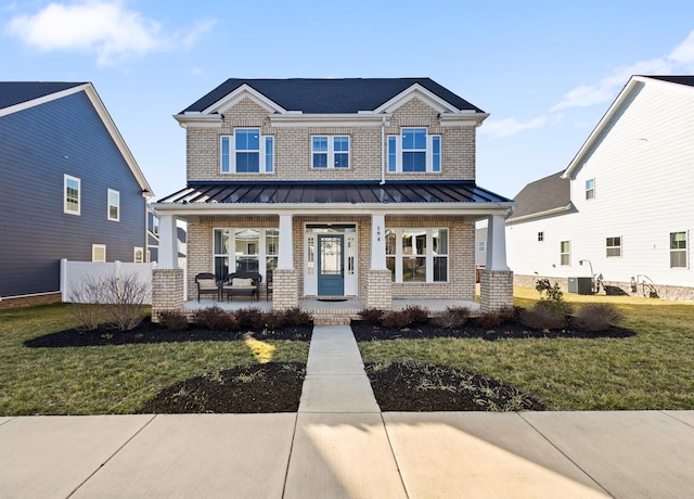 craftsman-style house with a standing seam roof, covered porch, and brick siding