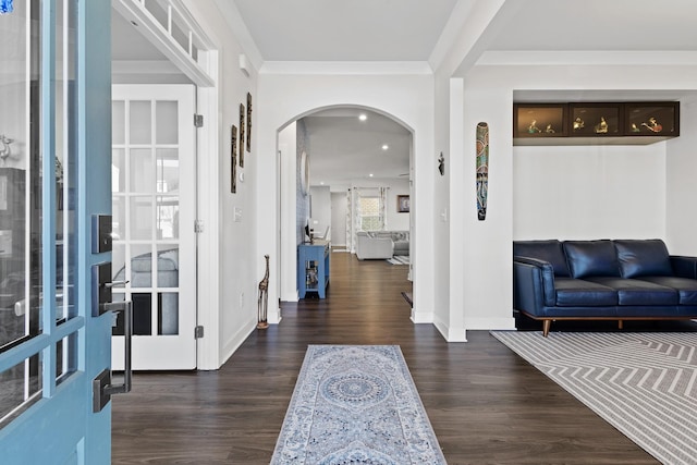 entryway featuring arched walkways, wood finished floors, and crown molding