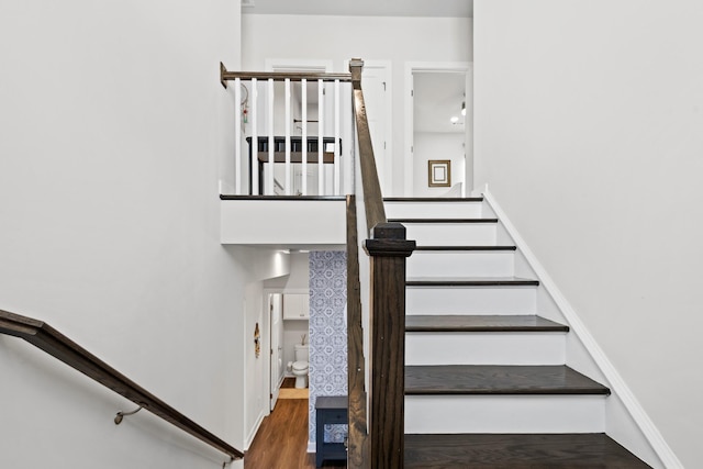 stairs featuring wood finished floors and baseboards