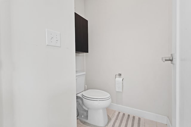 bathroom featuring toilet, baseboards, and tile patterned floors
