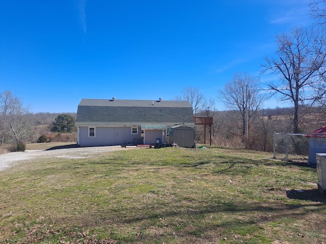 rear view of property featuring a storage shed, a gambrel roof, an outbuilding, a yard, and a patio area