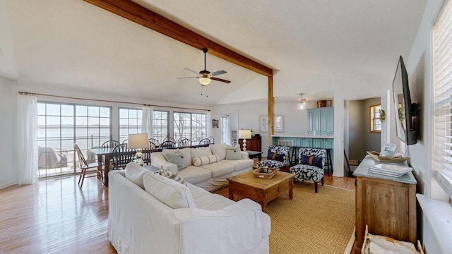 living room featuring vaulted ceiling with beams, light wood finished floors, and ceiling fan