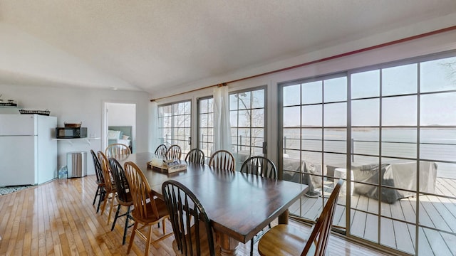 dining space with lofted ceiling and light wood finished floors