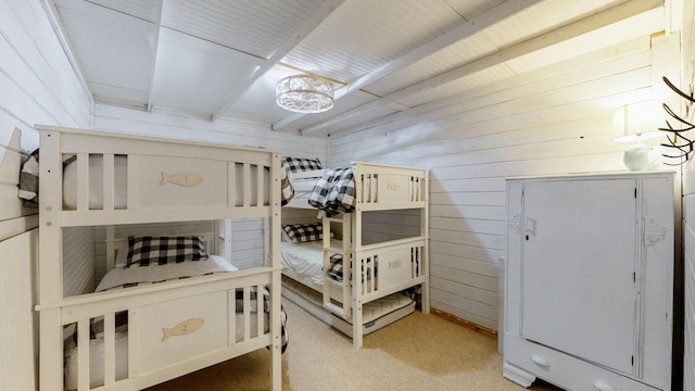 carpeted bedroom featuring wood walls