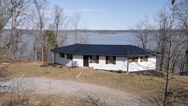 view of front facade featuring a water view, metal roof, and stucco siding