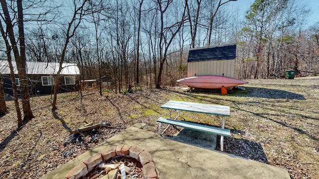 view of yard with an outbuilding, an outdoor fire pit, and a storage unit