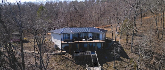 back of property featuring metal roof, stairway, and a wooded view