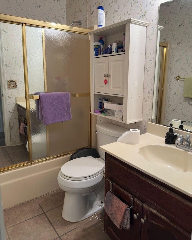 bathroom featuring wallpapered walls, toilet, shower / bath combination with glass door, tile patterned flooring, and vanity