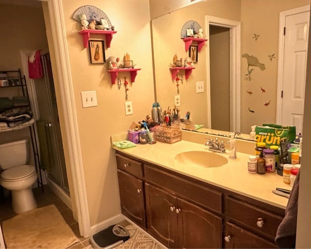 full bathroom with a stall shower, baseboards, toilet, tile patterned flooring, and vanity