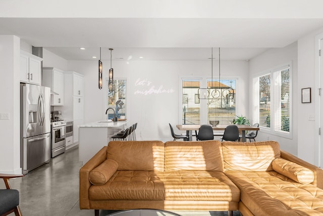 living area featuring recessed lighting, concrete floors, and an inviting chandelier