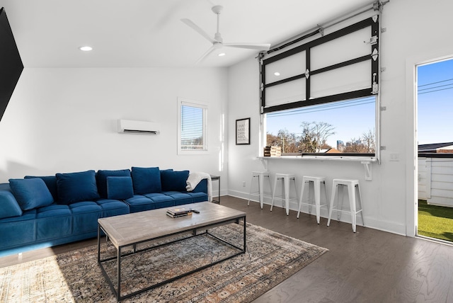 living area with recessed lighting, vaulted ceiling, an AC wall unit, and wood finished floors