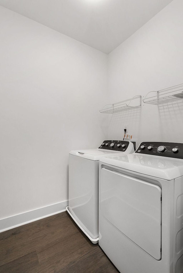 laundry area featuring laundry area, dark wood-style flooring, washing machine and clothes dryer, and baseboards