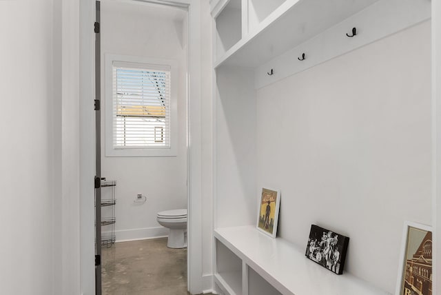 mudroom with concrete floors and baseboards