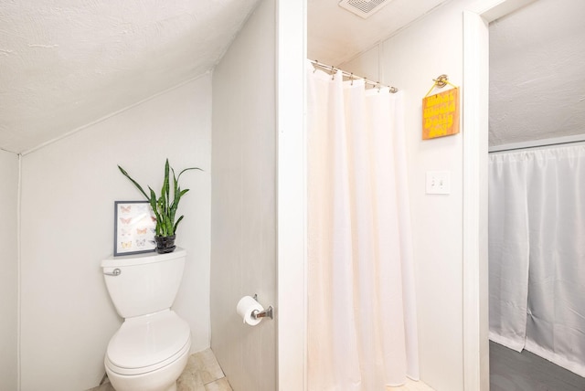 bathroom with visible vents, a textured ceiling, and toilet