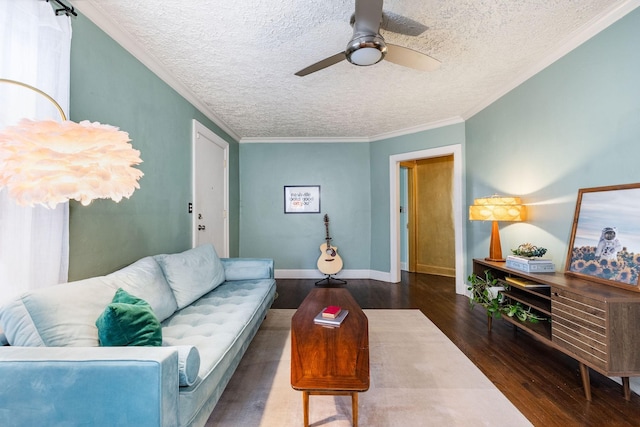 living room featuring baseboards, ceiling fan, a textured ceiling, crown molding, and wood finished floors