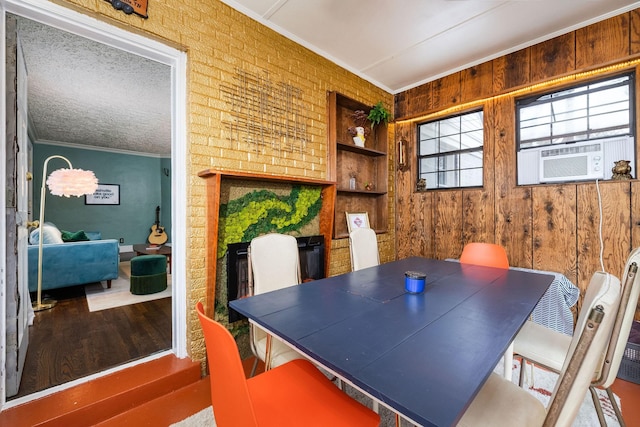 dining room with cooling unit, wood finished floors, ornamental molding, and built in features