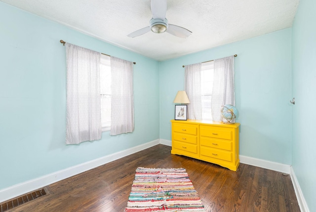 interior space with dark wood-type flooring, baseboards, visible vents, and plenty of natural light