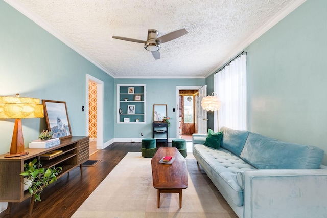 living room with built in features, ornamental molding, dark wood-style floors, a textured ceiling, and ceiling fan