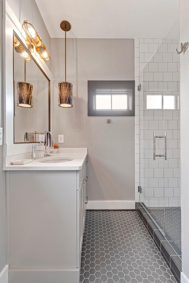 bathroom with tile patterned flooring, vanity, baseboards, and a shower stall