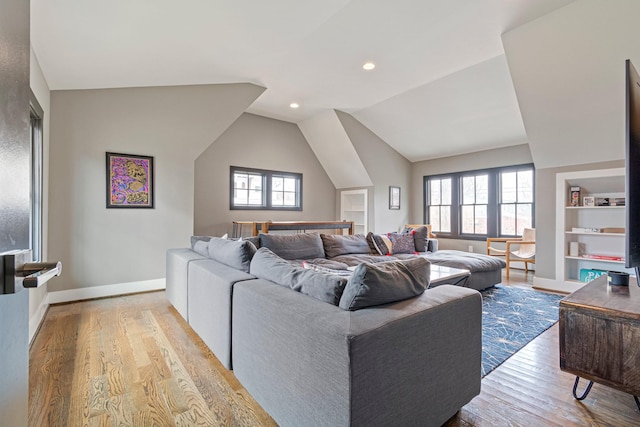 living room featuring built in features, lofted ceiling, recessed lighting, baseboards, and hardwood / wood-style flooring