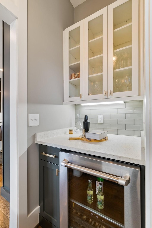 bar featuring wine cooler and backsplash