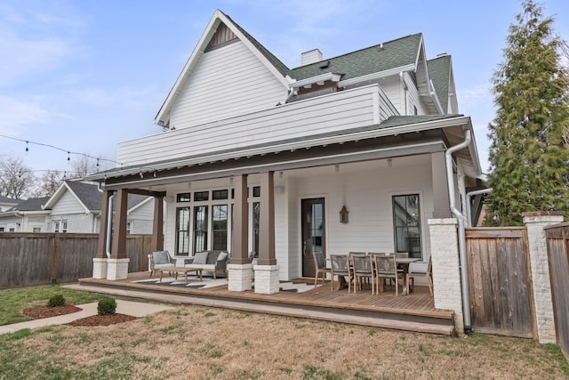 rear view of property featuring fence private yard, outdoor dining area, a deck, and roof with shingles