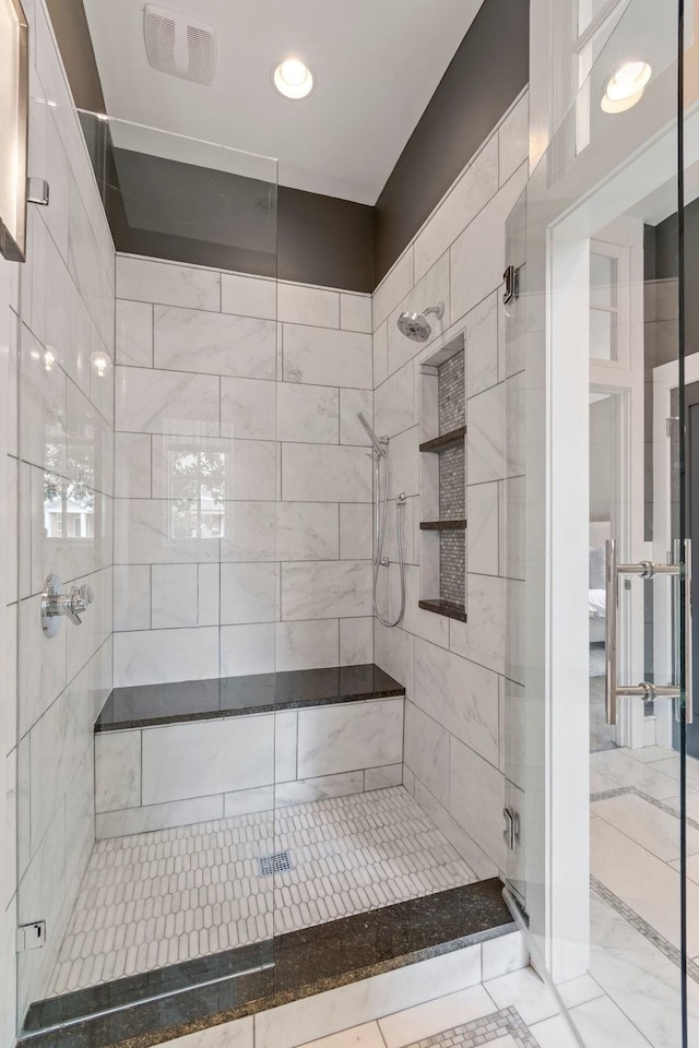 bathroom with a shower stall and visible vents