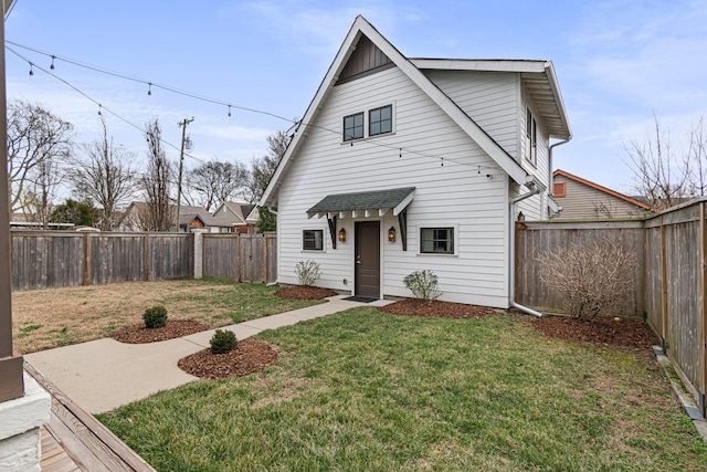 view of front facade with a front yard and a fenced backyard