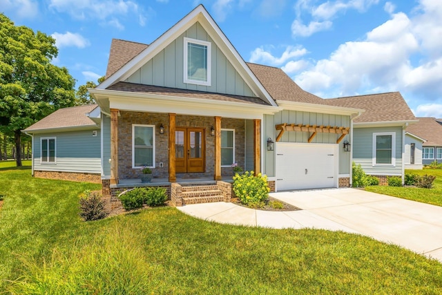 craftsman-style home featuring french doors, concrete driveway, board and batten siding, a garage, and a front lawn