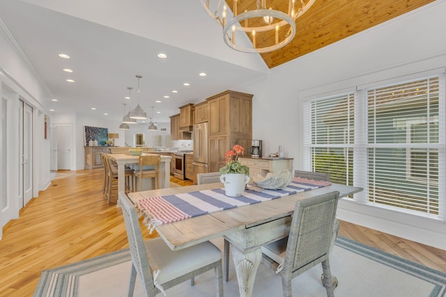 dining space featuring lofted ceiling, light wood finished floors, recessed lighting, and an inviting chandelier