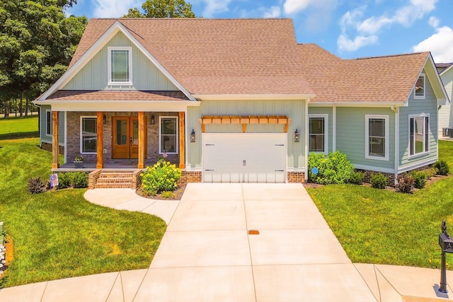 view of front facade featuring covered porch, board and batten siding, a front yard, a garage, and driveway