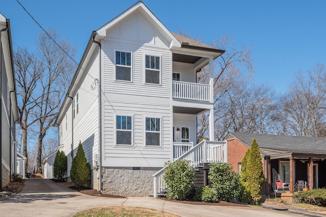 view of front facade with covered porch, driveway, crawl space, and board and batten siding