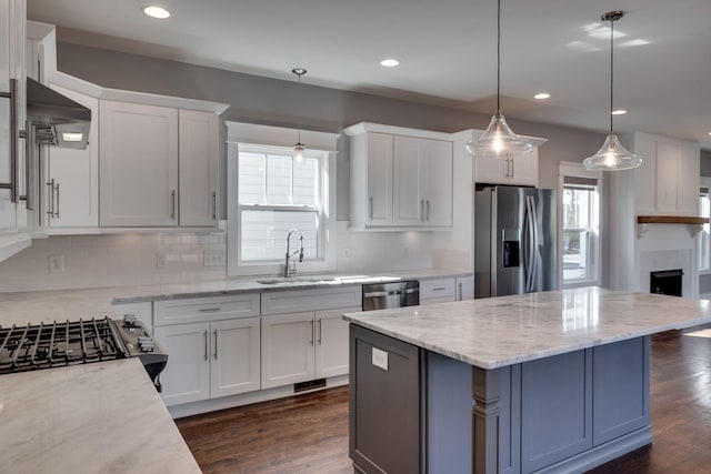 kitchen with stainless steel appliances, extractor fan, dark wood finished floors, and white cabinetry