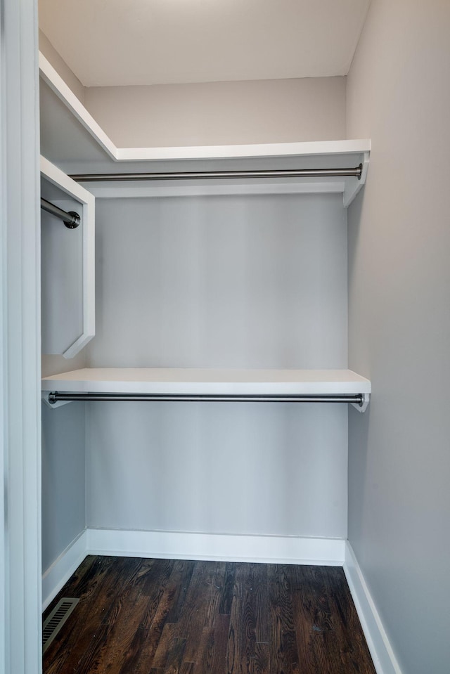 walk in closet featuring visible vents and dark wood finished floors