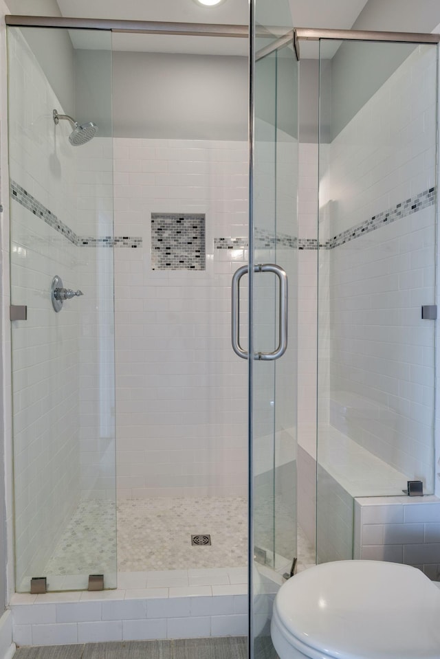 full bathroom with a stall shower and toilet